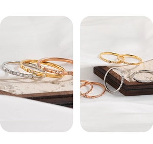 Detail of minimalist gold and silver stacked rings with micro-inlaid zircon stones