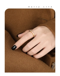 Detail van een luxe gouden titanium stalen ring met witte schelp op de hand van een model