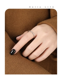 Detail showing a slim gold-plated stackable ring with minimalist pave-set diamonds on model