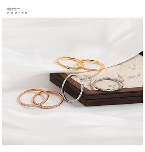 Close-up of a six-piece set of thin gold and silver stacking rings on silk and wood tray