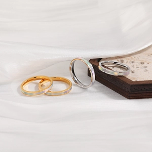 Gepolijste goud en zilver roestvrijstalen ringen met parelmoer inleg op een zijden basis