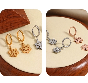 Makro-Detail von Schneeflocken-Ohrringen in Gold, Silber und Roségold mit mattem Finish