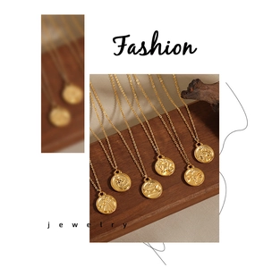 Detailed macro view of 24K gold plated zodiac coin necklaces on natural wood display