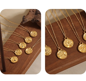 Detailed close-up of 24K gold plated zodiac coin necklaces on vintage wood display