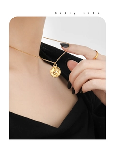 Detail of 24K gold plated Taurus zodiac coin necklace and matching ring on model