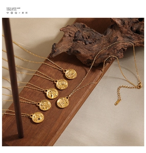Detailed macro of 24K gold plated zodiac coin necklaces on vintage wood background