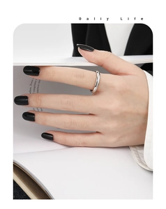 Détail d'une bague en argent avec zircons portée par un mannequin lisant un magazine