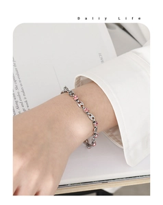 Detail of pig nose chain bracelet in silver finish with pink zircon stone inlay