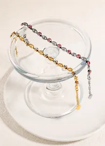 Detail of pig nose link bracelets with four-prong set crystals and heart charm in gold and silver