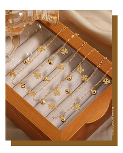 Nahaufnahme eines fünfteiligen Gold-Fußkettchen-Sets mit Kleeblatt und Glöckchen
