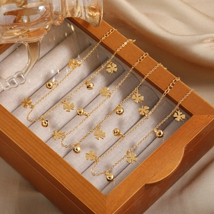 Minimalistisches Gold Kleeblatt und Glocke Fußkettchen Set in einer luxuriösen Schmuckbox