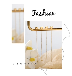 Detailed view of elegant gold heart tassel earrings with long chain links on white