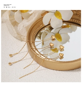 Detailed view of gold plated heart threader earrings with delicate long cable chains