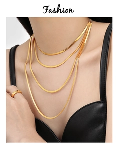 Détail de colliers multicouches en maille serpent dorée sur modèle avec finition brillante