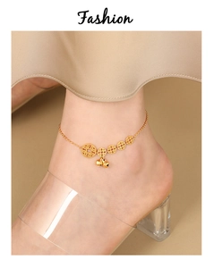 Detailed view of golden anklet featuring ancient coin charms and bells on the ankle