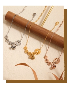Detailed view of gold and silver bell anklets with copper coins on a textured display