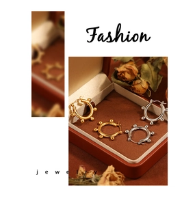 Detail of gold and silver beaded hoop earrings presented in a luxury jewelry box
