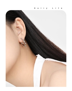 Close-up of silver beaded hoop earring on model showing minimalist titanium steel design