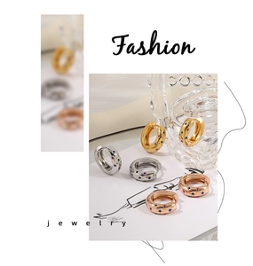 Chunky gold and silver hoop earrings with multicolored zircon inlay in macro view