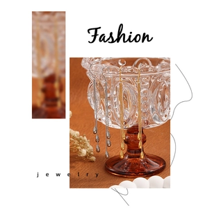 Λεπτομέρεια από κομψά σκουλαρίκια από ατσάλι τιτανίου σε χρυσό και ασήμι με σταγόνες