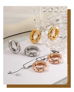 Detailed shot of gold, silver, and rose gold hoop earrings with multi-colored crystals