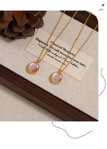 Detalle de collares dorados con piedras púrpuras en tela rústica con piñas de estilo vintage