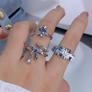 Gros plan de bagues en zircon bleu avec nœud et étoiles sur velours bleu doux