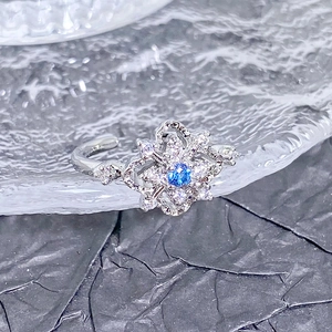Détail de la bague ajustable avec zircon bleu et cristaux brillants sur fond texturé