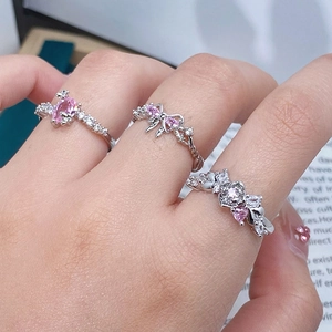 Detailed view of silver rings featuring pink zircon stones and butterfly heart shapes