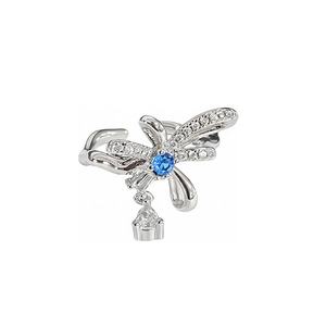 Bague nœud argentée avec pierre bleue et pendentif goutte sur fond blanc