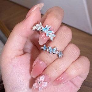 Détail de bagues papillon en émail bleu avec zircones blanches et design ajustable