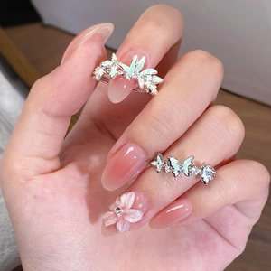 Détail de bagues en argent avec papillons en émail vert menthe et zircons brillants