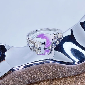 Détail de bague sirène avec émail violet, perle blanche et pierres de zircon
