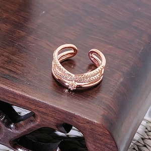 Dettaglio anello multistrato in oro rosa con pavé di zirconi e motivo a stella
