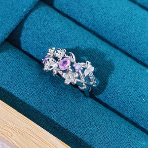Detail of floral vine ring with pink oval stone and purple accents on velvet