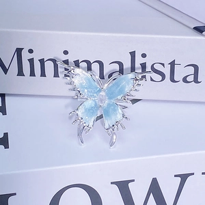 Gros plan d'une bague papillon en argent avec émail bleu clair et petit cristal