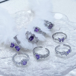Silver ring set with purple gems and butterfly design on white faux fur background