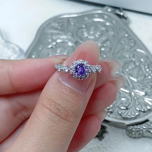 Macro shot of a floral ring featuring a purple gemstone and a cluster of micro-diamonds