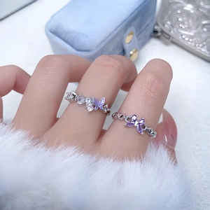 Detailed view of silver rings featuring purple butterfly designs and zircon stones