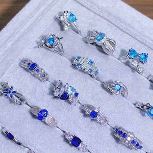 Set di anelli in argento con zirconi blu e motivi a farfalla e geometrici su velluto