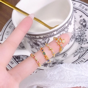 Detail of four vintage gold rings with colorful zircons and star motif on a lace setting