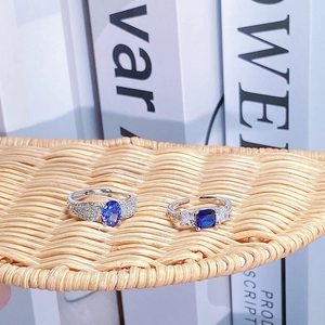 Dettaglio macro di anelli in argento regolabili con zaffiri blu su trama intrecciata