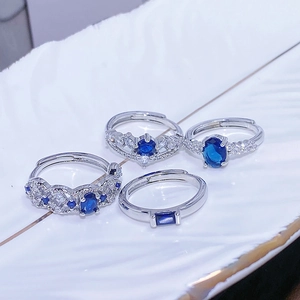 Dettaglio di quattro anelli aperti argento con pietre blu e zirconi incastonati