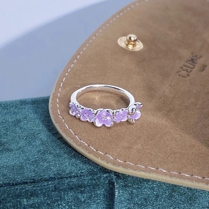 Vista dettagliata di un anello a fiori in smalto viola su uno sfondo in pelle