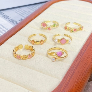 Detail view of a six-piece vintage enamel ring set with zircon accents in a jewelry box