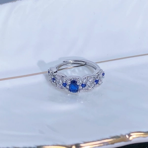 Vista macro di un anello regolabile in argento con pietra blu e zirconi incastonati a pavé