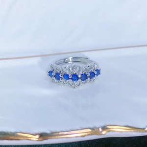 Vista macro di un anello regolabile in argento con sette pietre blu e dettagli zirconi