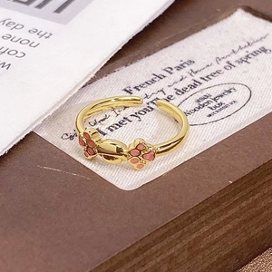 Detailed close-up of adjustable ring with pink enamel cat paw design and gold plating