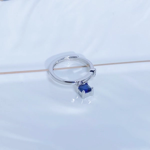 Dettaglio di un anello regolabile in argento con gemma blu quadrata e zirconi micro