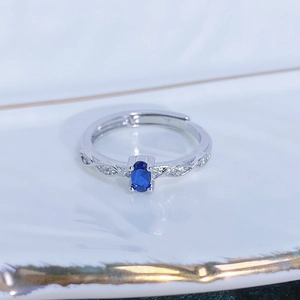 Macro di anello con zircone blu mare ovale e fascia intrecciata con pavé di zirconi